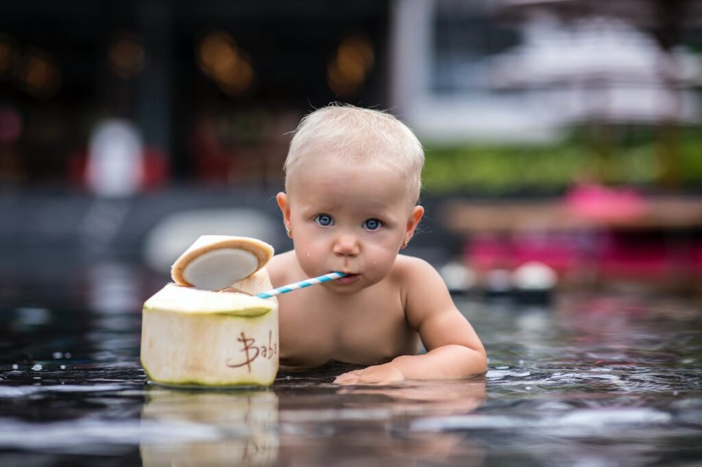 a baby drinking from a coconut